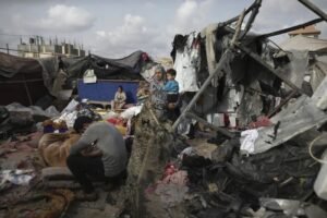 Displaced Palestinians survey destroyed tents in Rafah.